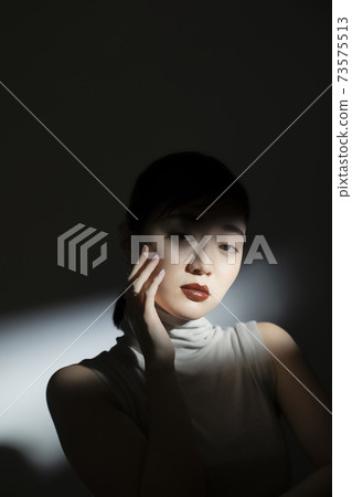 Dramatic female portrait in light and shadow Dramatic female portrait in light and shadow 73575513
