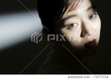 Dramatic female portrait in light and shadow Dramatic female portrait in light and shadow 73575728
