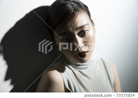 Dramatic female portrait in light and shadow Dramatic female portrait in light and shadow 73575854