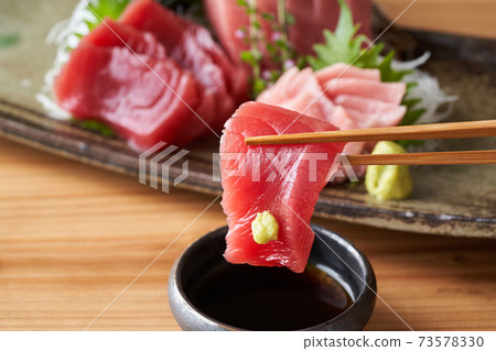 將這種沙丁魚的生魚片浸泡在醬油中 將這種沙丁魚的生魚片浸泡在醬油中 73578330