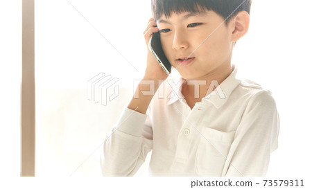 Boy talking on a smartphone Boy talking on a smartphone 73579311