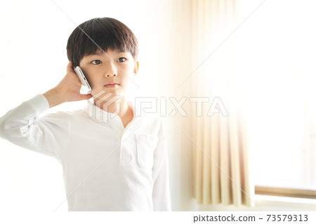 Boy talking on a smartphone Boy talking on a smartphone 73579313