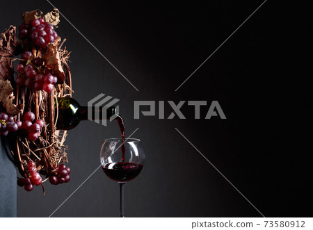 Red wine pouring from a bottle into a glass. Red wine pouring from a bottle into a glass. 73580912