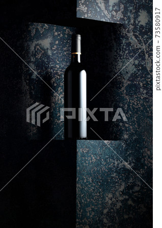 Unopened bottle of red wine on a background of old wall. Unopened bottle of red wine on a background of old wall. 73580917