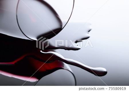 Glass of red wine on a black reflective background. 73580919