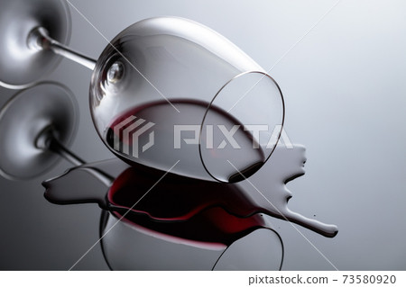 Glass of red wine on a black reflective background. 73580920