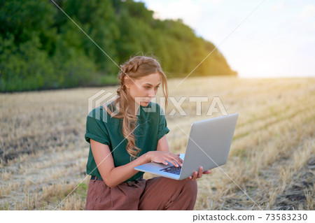 Woman farmer smart farming standing farmland smiling using laptop Female agronomist specialist research monitoring analysis data agribusiness 73583230