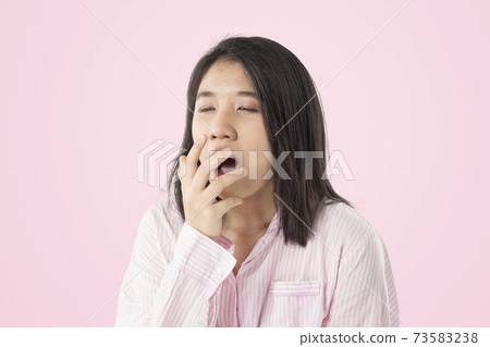 young asian woman wear pink pajamas yawn feeling sleepy young asian woman wear pink pajamas yawn feeling sleepy 73583238