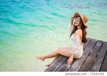 happy woman sitting on a wooden bridge in sea beach at Koh MunNork Island, Rayong, Thailand 73583392
