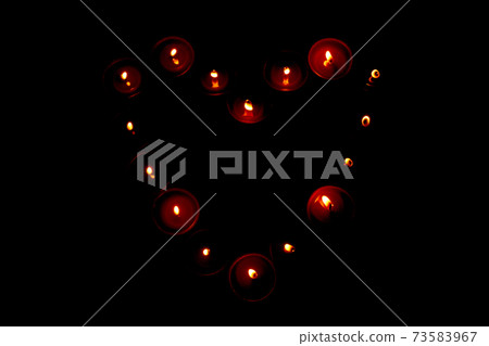 Red candles in the shape of heart on black background, concept of Valentine's Day. 73583967