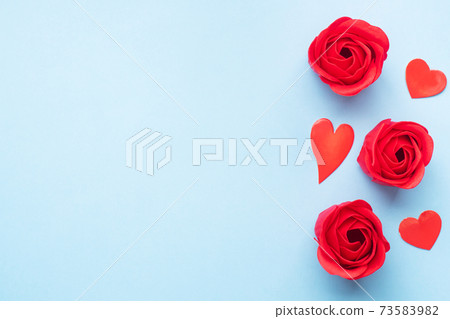 Handmade soap in the shape of a rose, red rose flower on a blue background. Top view, minimalist, copy space. Handmade soap in the shape of a rose, red rose flower on a blue background. Top view, minimalist, copy space. 73583982