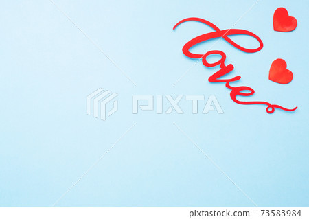 The word Love and red hearts on a blue background, top view. Holiday card for Valentine's Day. Flat lay. The word Love and red hearts on a blue background, top view. Holiday card for Valentine's Day. Flat lay. 73583984