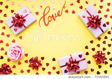 Valentine day composition, Greeting gift box with confetti hearts on yellow background. Flat lay. 73583992