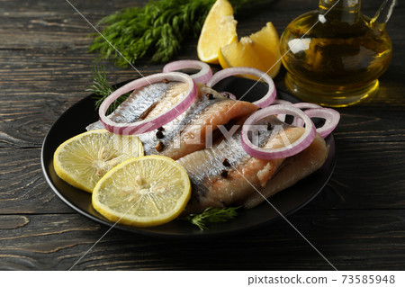 Concept of tasty lunch with herring fish on wooden background Concept of tasty lunch with herring fish on wooden background 73585948