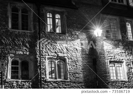 Illuminated windows in Trinity Lane by night, Cambridge, UK 73586719