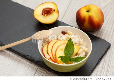 Sorghum salad with nuts and fresh peach on stone board. Sorghum salad with nuts and fresh peach on stone board. 73587253