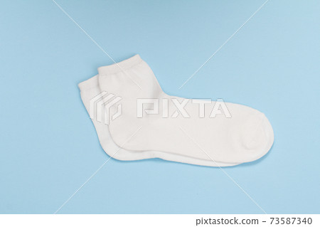 Pair of white women socks on blue background. Pair of white women socks on blue background. 73587340