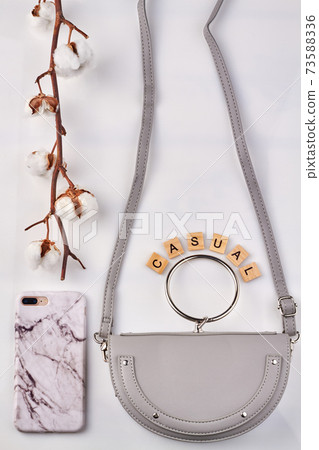 Branch of white cotton near fashionable things. Branch of white cotton near fashionable things. 73588336