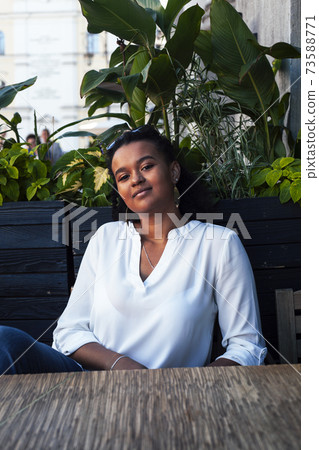 young pretty african girl posing cheerful in cafe outdoor, lifestyle people concept young pretty african girl posing cheerful in cafe outdoor, lifestyle people concept 73588771