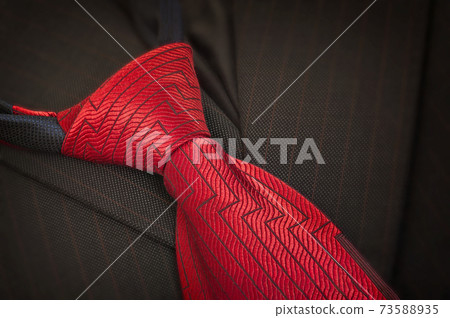 Red male silk necktie close-up on dark background of suit jacket. Happy Father day concept Red male silk necktie close-up on dark background of suit jacket. Happy Father day concept 73588935