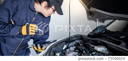 Asian auto mechanic checking the car using tablet Asian auto mechanic checking the car using tablet 73590024