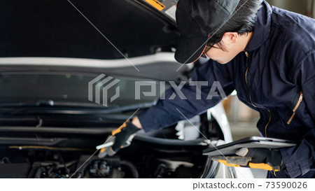 Asian auto mechanic checking the car using tablet Asian auto mechanic checking the car using tablet 73590026