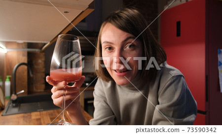 Woman takes off mask to smell fresh vegetables in kitchen 73590342