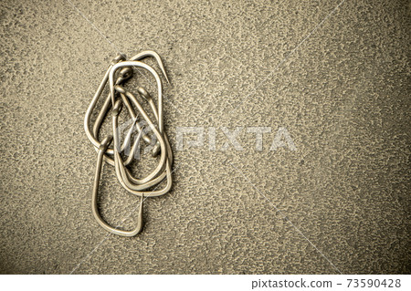 Fishing hooks on concrete textured background macro 73590428