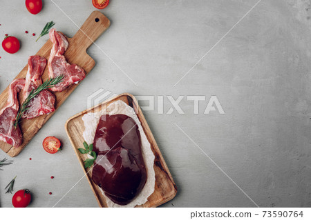 Raw beef liver and beef steaks on wooden cutting board Raw beef liver and beef steaks on wooden cutting board 73590764