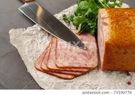 Meat sausage on parchment on gray background Meat sausage on parchment on gray background 73590776
