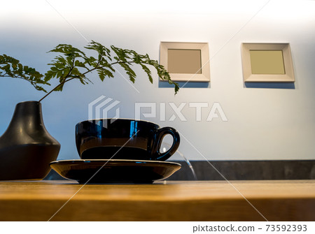 Coffee cup on wood table with fern leaf Coffee cup on wood table with fern leaf 73592393