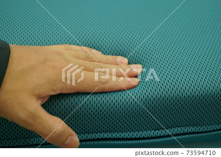 Hands to check the softness of the cushion 73594710