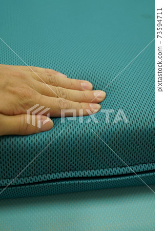 Hands to check the softness of the cushion 73594711