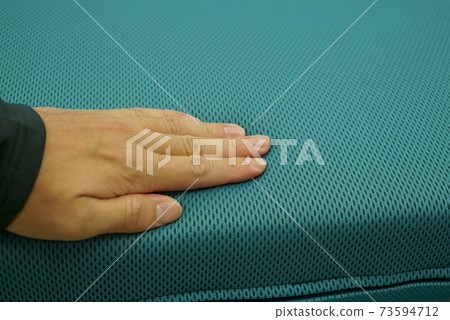 Hands to check the softness of the cushion 73594712