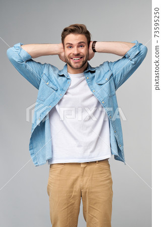 young man with ears closed standing over grey studio background young man with ears closed standing over grey studio background 73595250