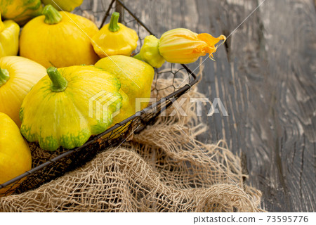 Patisson, Squash, dish-shaped pumpkin, raw vegetable on a dark wooden background. 73595776