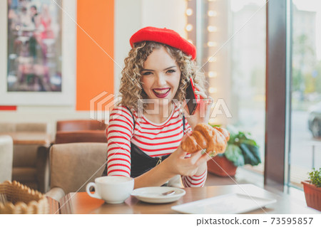 Young woman laughing in european city street cafe 73595857