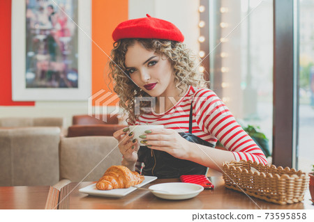 Attractive woman drinking coffee in cafe Attractive woman drinking coffee in cafe 73595858