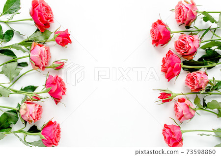 Flower border frame made of red roses on white background with copy space for text. Valentine's background. Floral pattern. Flat lay, top view.  73598860