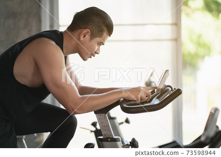 sport man riding a bike at the gym, sport concept 73598944