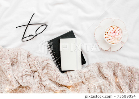 Home office on bed with warm plaid. Mockup card. Flat lay, top view 73599054