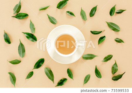 Cup of fresh green tea with tea leaves. Flat lay, top view. Tea concept 73599533
