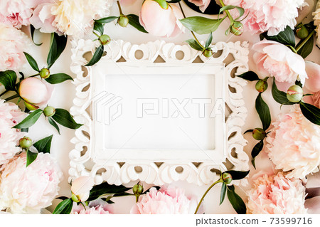 Carved, white frame decorated of beautiful pink peonies on white background. Flat lay, top view. Valentine's background. Floral frame. Peony texture. Carved, white frame decorated of beautiful pink peonies on white background. Flat lay, top view. Valentine's background. Floral frame. Peony texture. 73599716