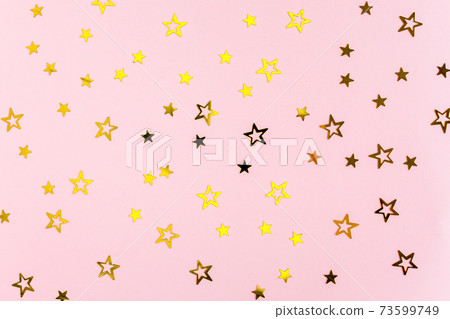 Confetti golden stars on pink background. Holiday backdrop. Colorful celebration, birthday. Christmas or New Year pattern. Flat lay, top view Confetti golden stars on pink background. Holiday backdrop. Colorful celebration, birthday. Christmas or New Year pattern. Flat lay, top view 73599749