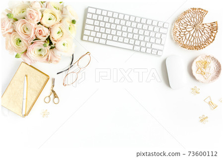 Stylized women's home office desk. Workspace with computer, bouquet ranunculus and roses, clipboard on white background. Flat lay. Top view. 73600112