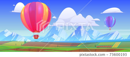 Hot air balloons fly above mountain landscape 73600193