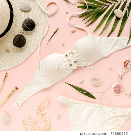 Traveler accessories, women summer bikini set swimsuit, tropical palm leaf branches on pink background. Travel vacation concept. Flat lay, top view. Traveler accessories, women summer bikini set swimsuit, tropical palm leaf branches on pink background. Travel vacation concept. Flat lay, top view. 73600515