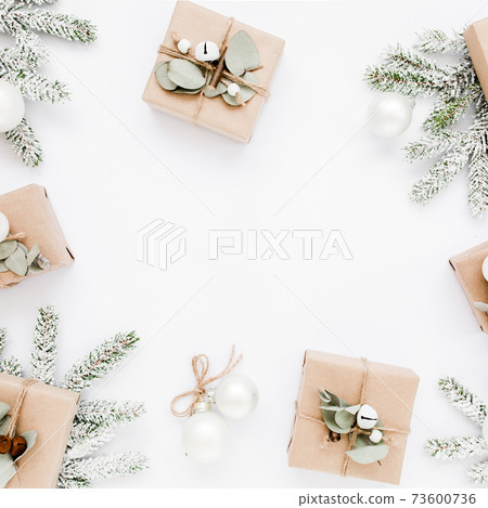 Christmas frame, pattern made in of craft boxes and green branches in the snow. Holiday and celebration concept. Top view. Flat lay Christmas frame, pattern made in of craft boxes and green branches in the snow. Holiday and celebration concept. Top view. Flat lay 73600736