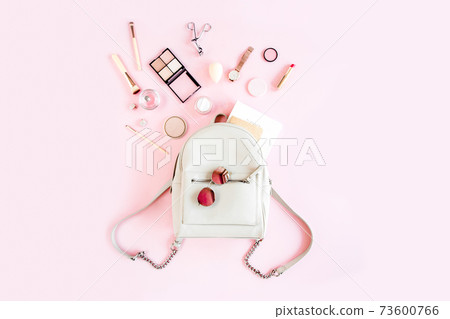 Women beige backpack and accessories on pink background top view. Flat lay female style look. Top view. 73600766