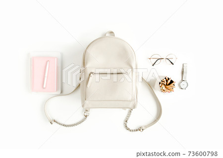 Women's beige backpack with fashion accessories on white background top view. Flat lay female style look. Top view. 73600798